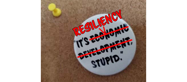 A button on a bulletin board reads "It's Resiliency, Stupid."